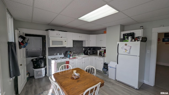 kitchen featuring a paneled ceiling, white appliances, white cabinetry, and light wood-style flooring