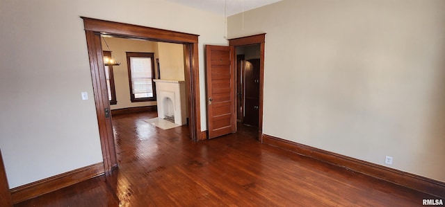 814 W Edwards St, Springfield, IL 62704 - unfurnished bedroom with baseboards, dark wood-type flooring, and a fireplace with flush hearth