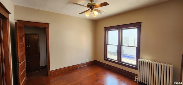 814 W Edwards St, Springfield, IL 62704 - empty room featuring radiator, dark wood-style floors, baseboards, and ceiling fan