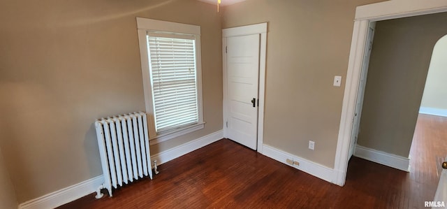 814 W Edwards St, Springfield, IL 62704 - unfurnished bedroom with radiator, dark wood-style floors, and baseboards