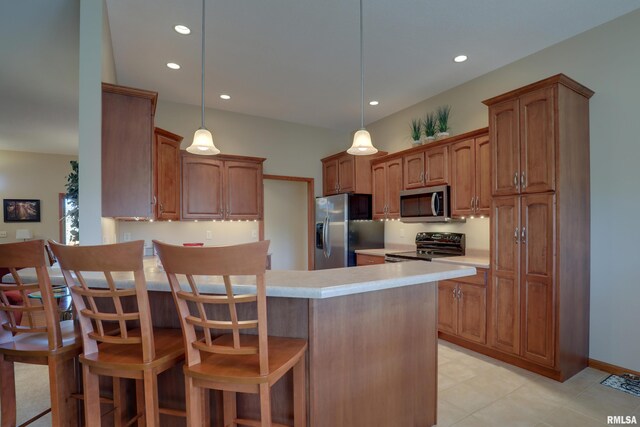 kitchen featuring a kitchen breakfast bar, decorative light fixtures, a peninsula, stainless steel appliances, and light countertops