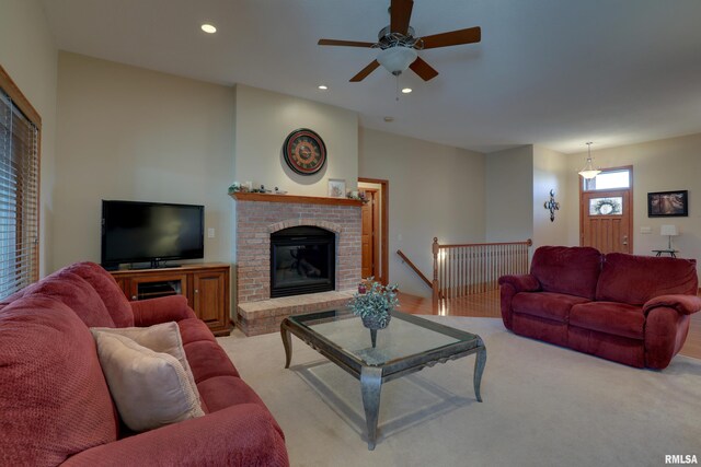 living area with a brick fireplace, light colored carpet, and recessed lighting