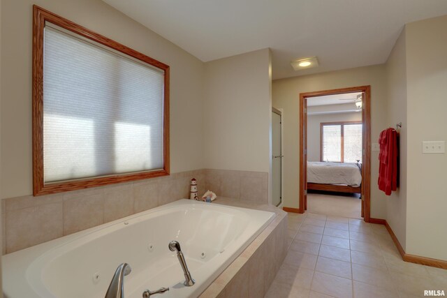 ensuite bathroom with connected bathroom, a jetted tub, baseboards, and tile patterned floors