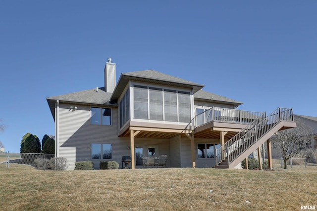 back of house featuring fence, a yard, stairway, a wooden deck, and a chimney