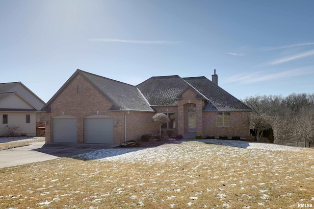 view of front of home featuring an attached garage, a chimney, concrete driveway, and brick siding