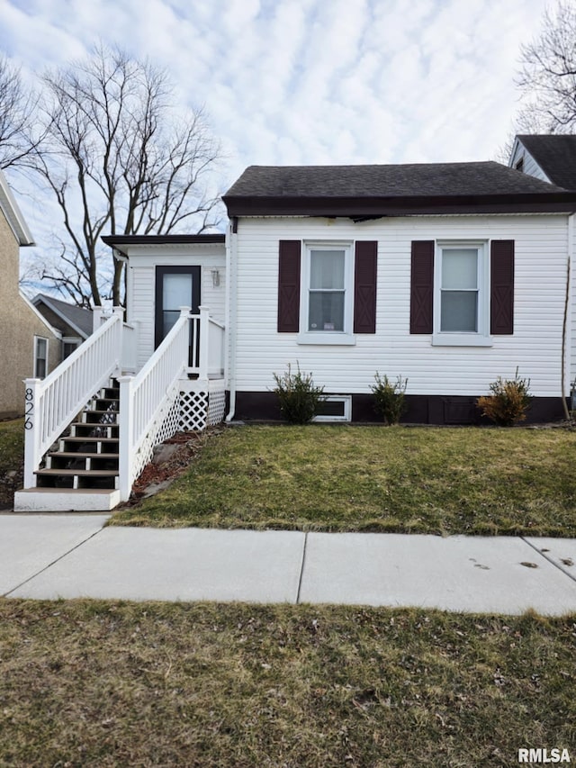 view of front facade with a front lawn and roof with shingles