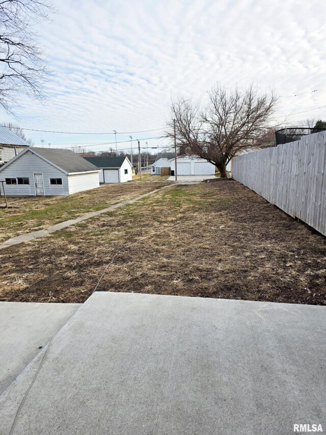 view of yard featuring a detached garage and fence