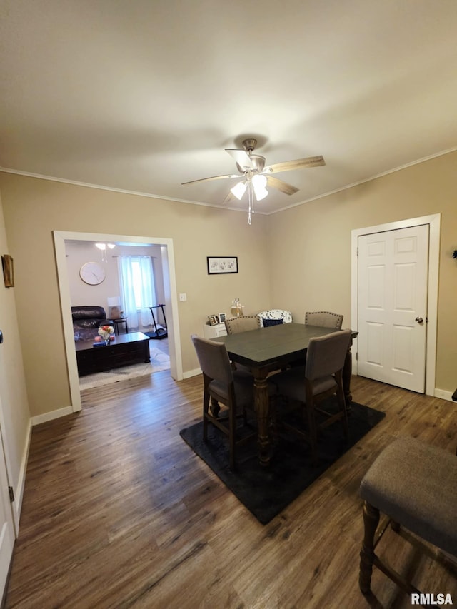 dining area featuring a ceiling fan, dark wood-type flooring, crown molding, and baseboards