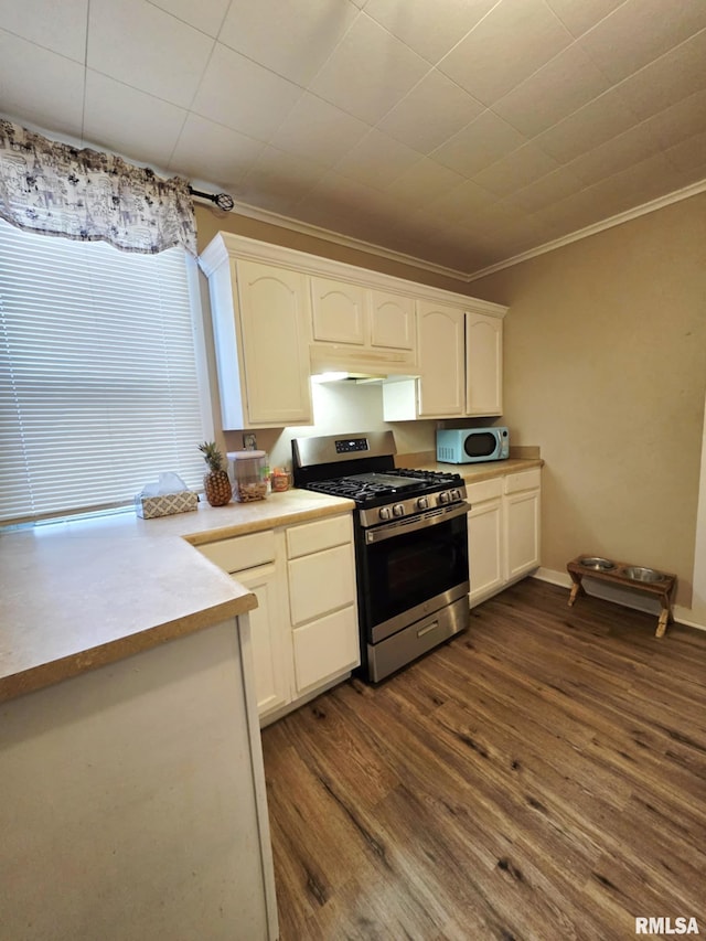 kitchen with stainless steel gas range oven, ornamental molding, white cabinetry, light countertops, and dark wood-style flooring