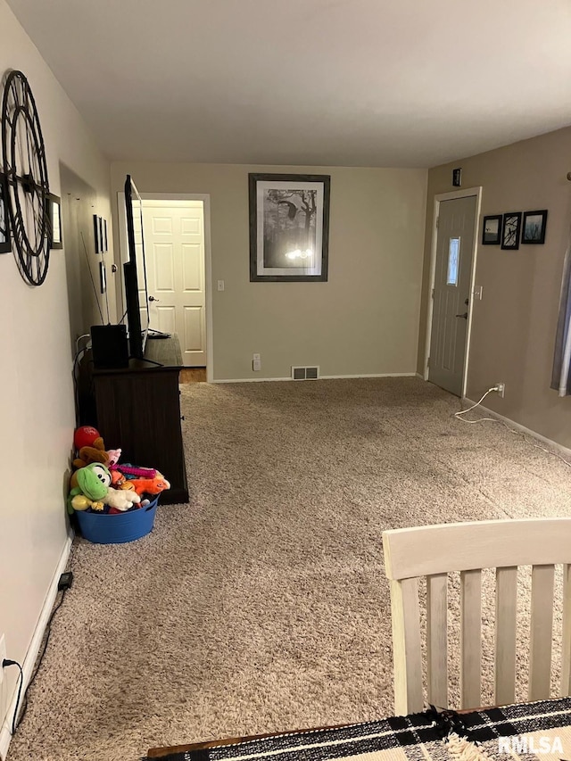 entryway with carpet floors, visible vents, and baseboards