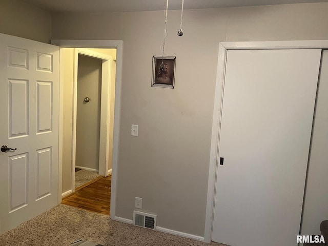 hall featuring carpet, visible vents, and baseboards