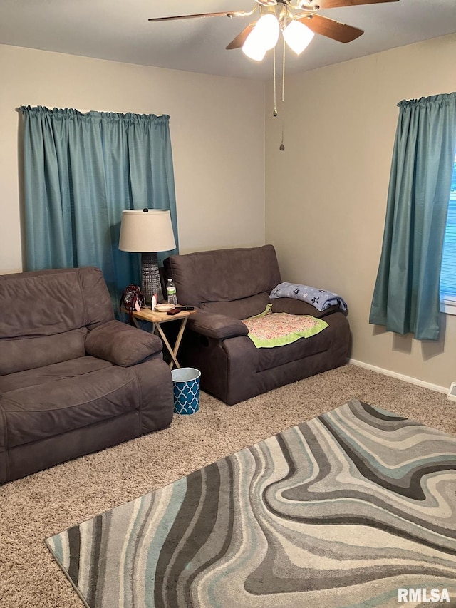 carpeted living room featuring a ceiling fan and baseboards