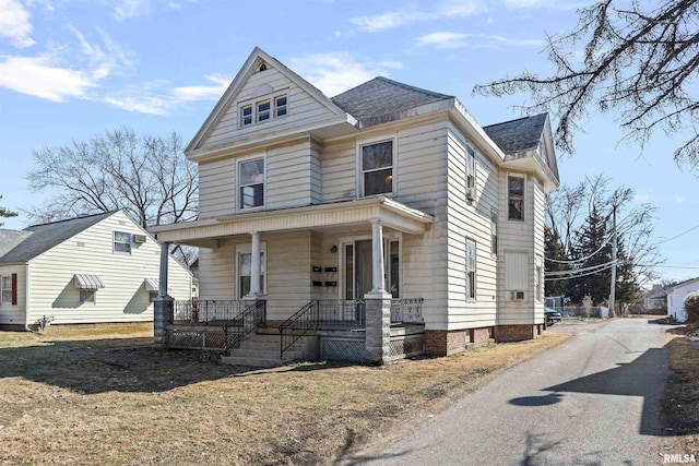 traditional style home with a porch and a shingled roof