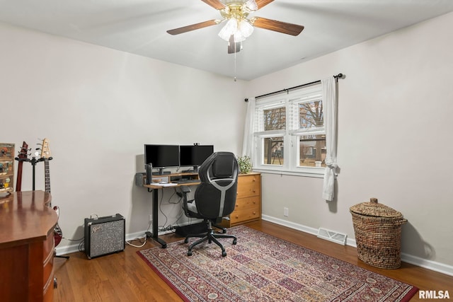 office space with a ceiling fan, wood finished floors, visible vents, and baseboards