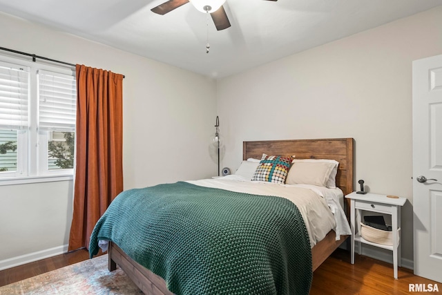 bedroom featuring a ceiling fan, baseboards, and wood finished floors