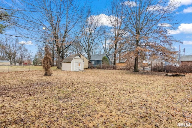 view of yard with a storage unit, an outdoor structure, and fence