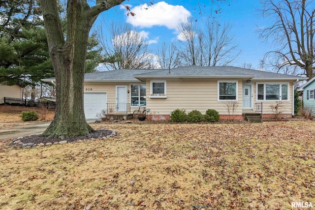 ranch-style home featuring an attached garage and fence