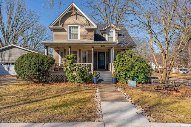 view of front of home with covered porch, a shingled roof, and a front lawn