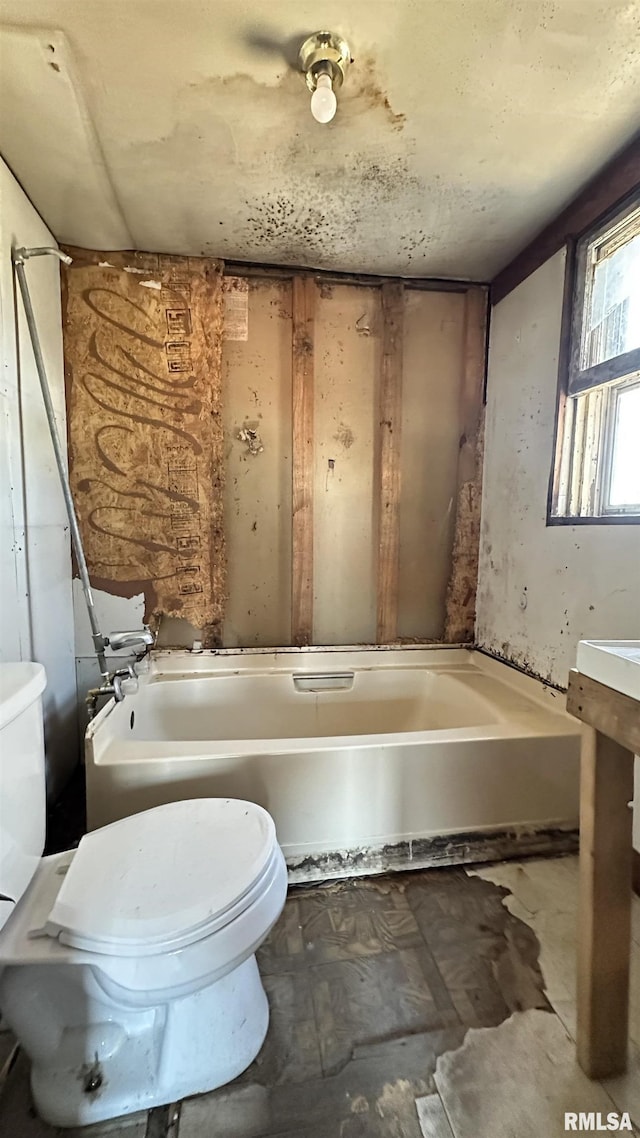 bathroom featuring a washtub and toilet