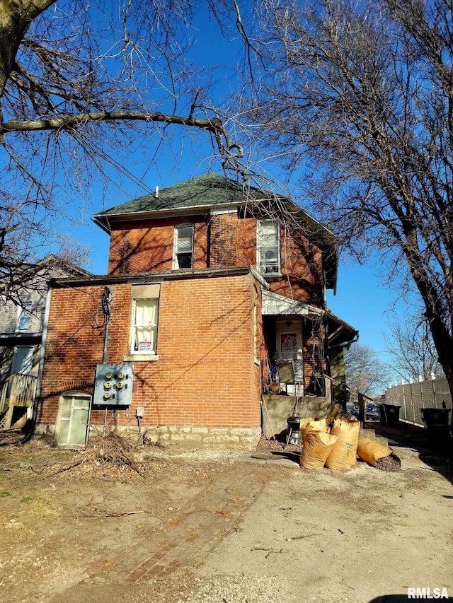 view of property exterior with fence and brick siding