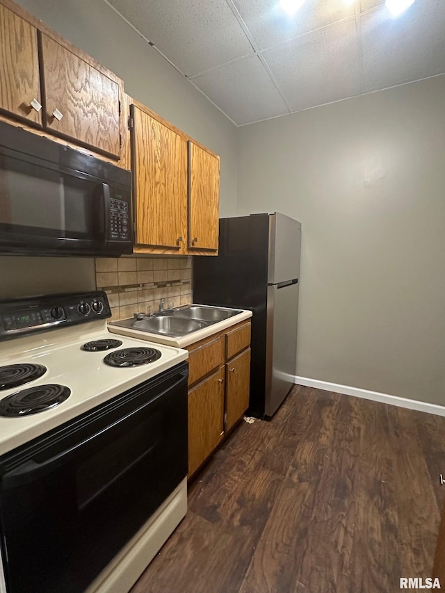 kitchen featuring range with electric cooktop, a sink, dark wood-style floors, black microwave, and decorative backsplash