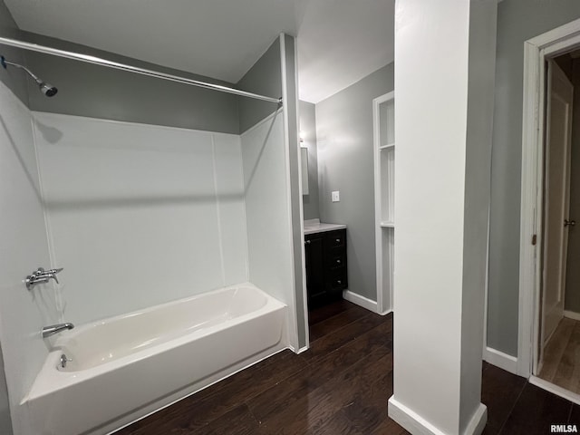 full bath featuring vanity, shower / bath combination, baseboards, and wood finished floors