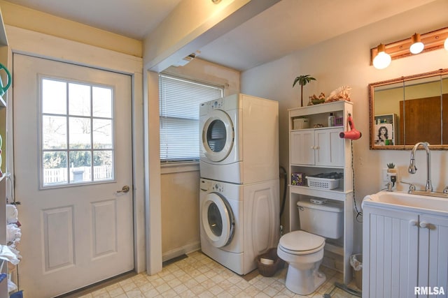 washroom with laundry area, light floors, stacked washer / drying machine, and a sink