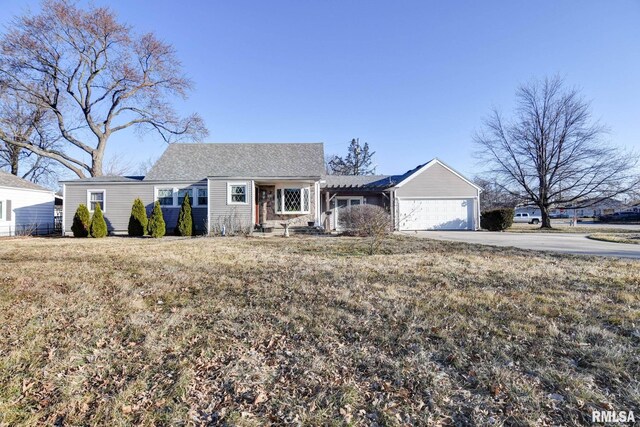 ranch-style home with a garage, concrete driveway, and a front lawn