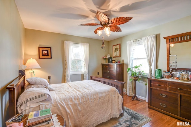 bedroom with multiple windows, wood finished floors, and a ceiling fan