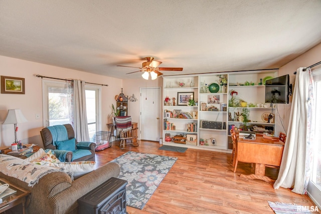 living area featuring light wood-style flooring and a ceiling fan