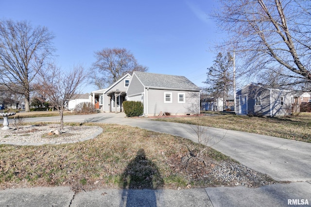 view of side of home featuring driveway and a yard