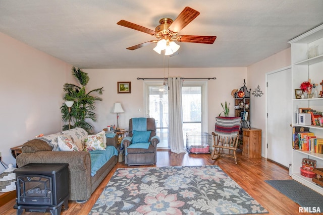 living area with a ceiling fan and wood finished floors