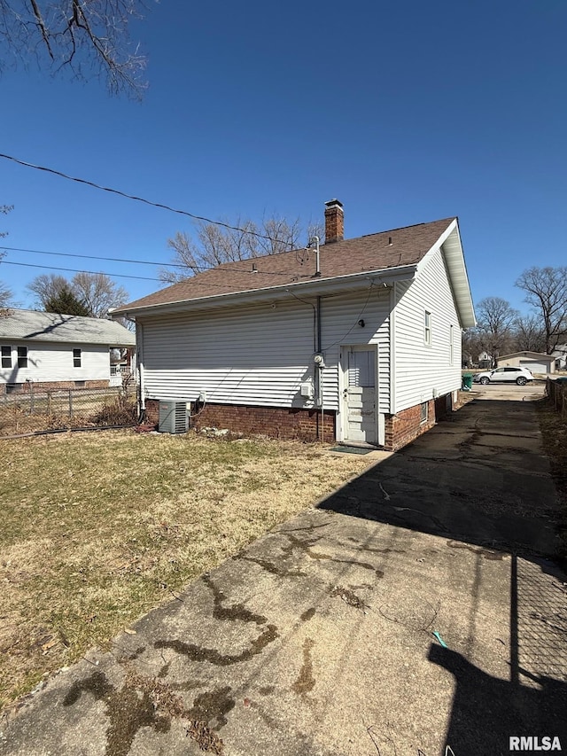 back of house with a lawn, cooling unit, a chimney, and fence