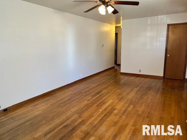 unfurnished room featuring wood finished floors, baseboards, and ceiling fan