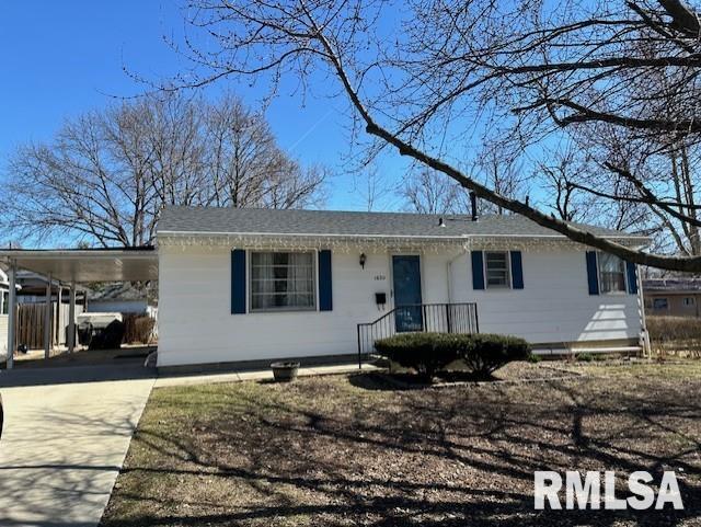 ranch-style home with a carport and driveway