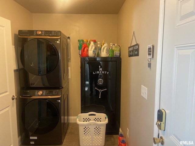 laundry area with laundry area, stacked washer / dryer, and baseboards