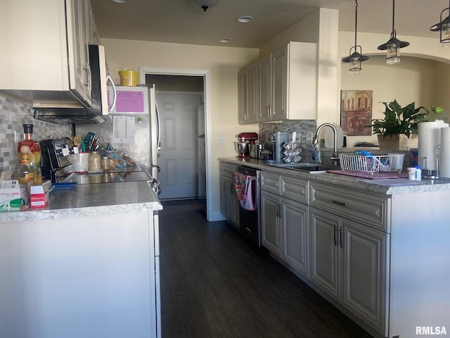 kitchen featuring a sink, backsplash, stainless steel appliances, white cabinetry, and dark wood-style flooring