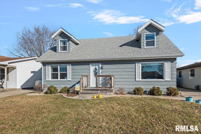 cape cod home with a shingled roof and a front yard