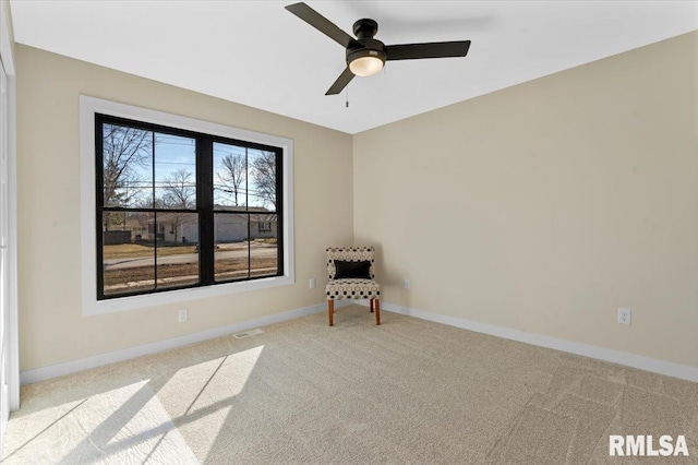 carpeted spare room featuring visible vents, baseboards, and ceiling fan