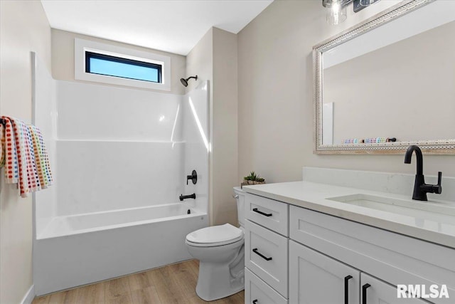 bathroom featuring bathtub / shower combination, vanity, toilet, and wood finished floors