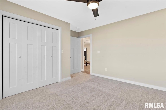 unfurnished bedroom with a closet, baseboards, carpet, and a ceiling fan