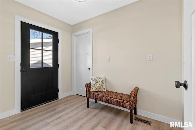 foyer entrance featuring baseboards, visible vents, and light wood-type flooring