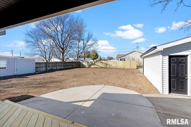 view of yard with an outbuilding, a fenced backyard, and a patio area