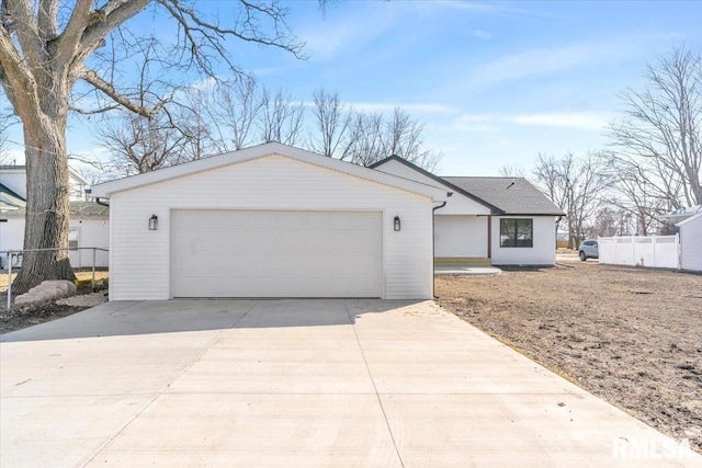 single story home with an outbuilding, a garage, and fence