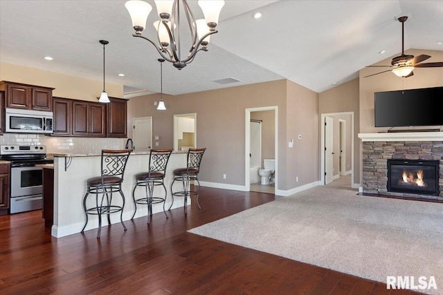 kitchen with visible vents, backsplash, open floor plan, a breakfast bar, and appliances with stainless steel finishes