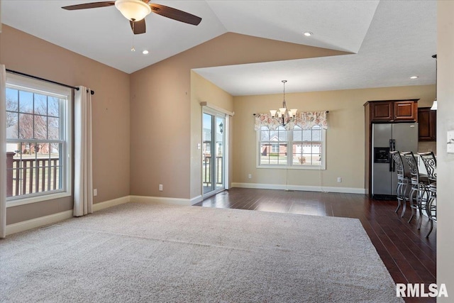 interior space featuring ceiling fan with notable chandelier, baseboards, dark wood-type flooring, and lofted ceiling