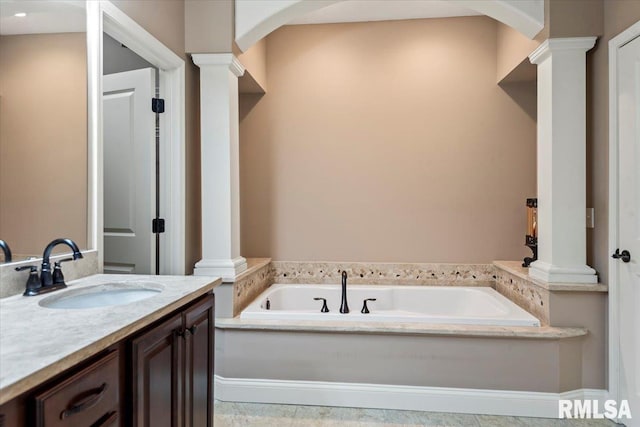 bathroom with a garden tub, vanity, and ornate columns