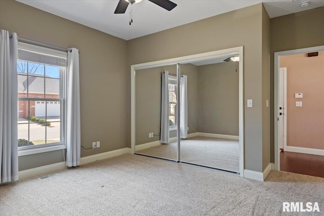 unfurnished bedroom with carpet flooring, multiple windows, and baseboards