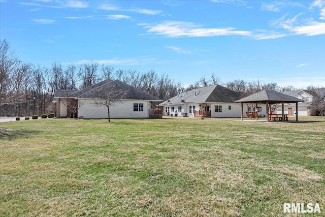 rear view of property featuring a gazebo and a lawn