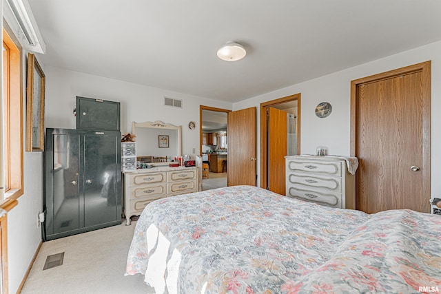 bedroom featuring baseboards, visible vents, a closet, and light carpet